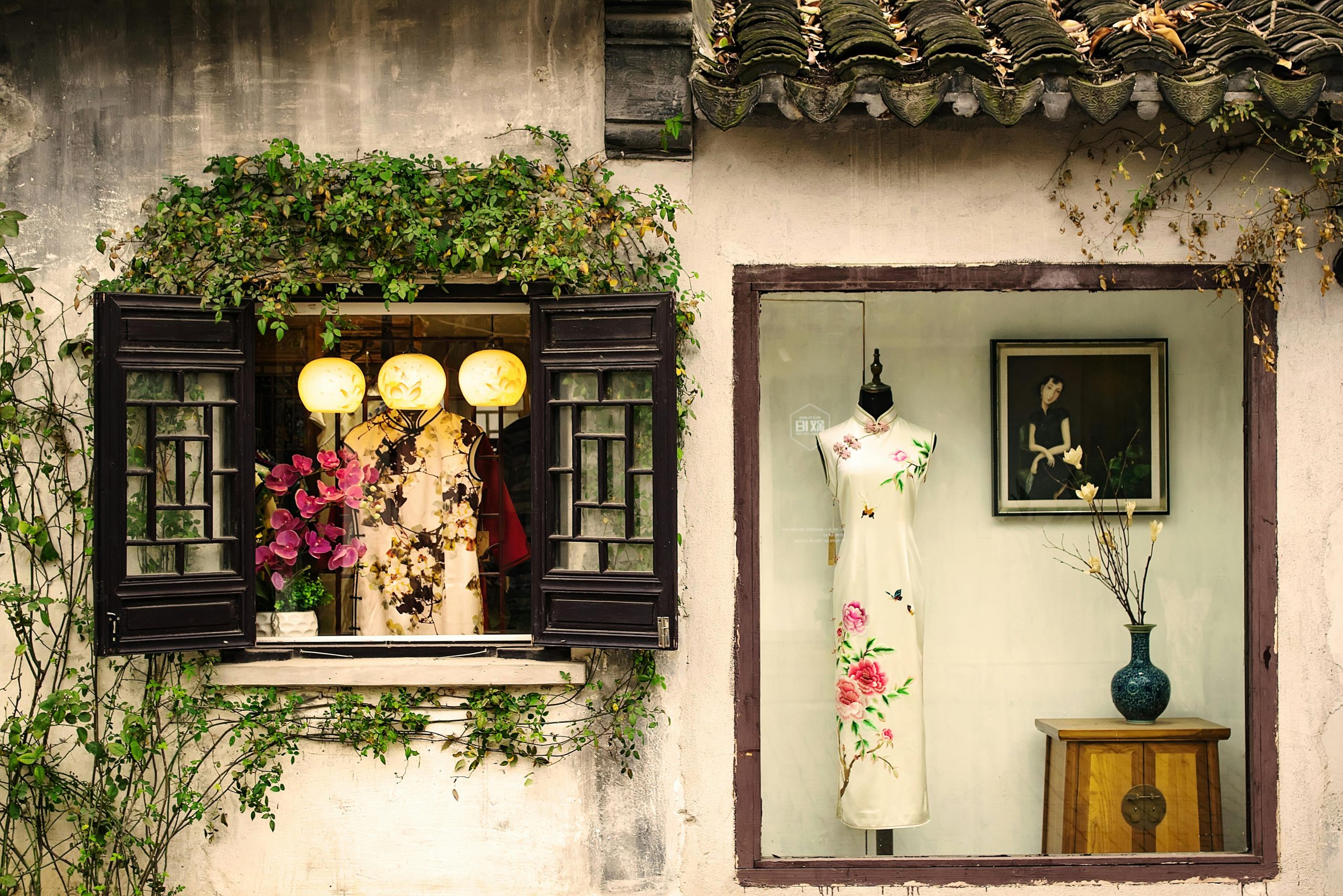 Beautiful display of traditional Chinese dresses in a quaint vintage shop window. Affichage magnifique de robes traditionnelles chinoises dans la vitrine pittoresque d'une boutique vintage.