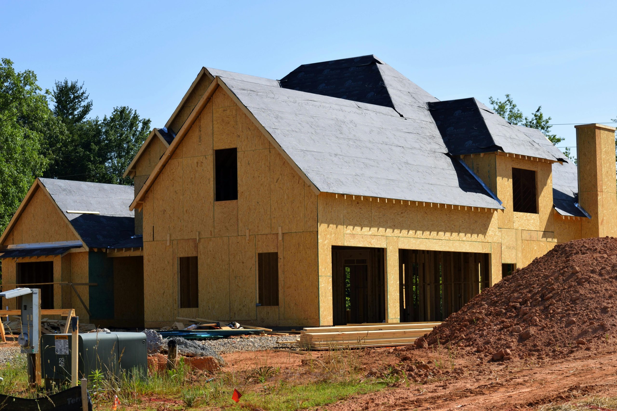 Une maison en bois partiellement construite en cours de construction, montrant son avancement et son design en plein jour.