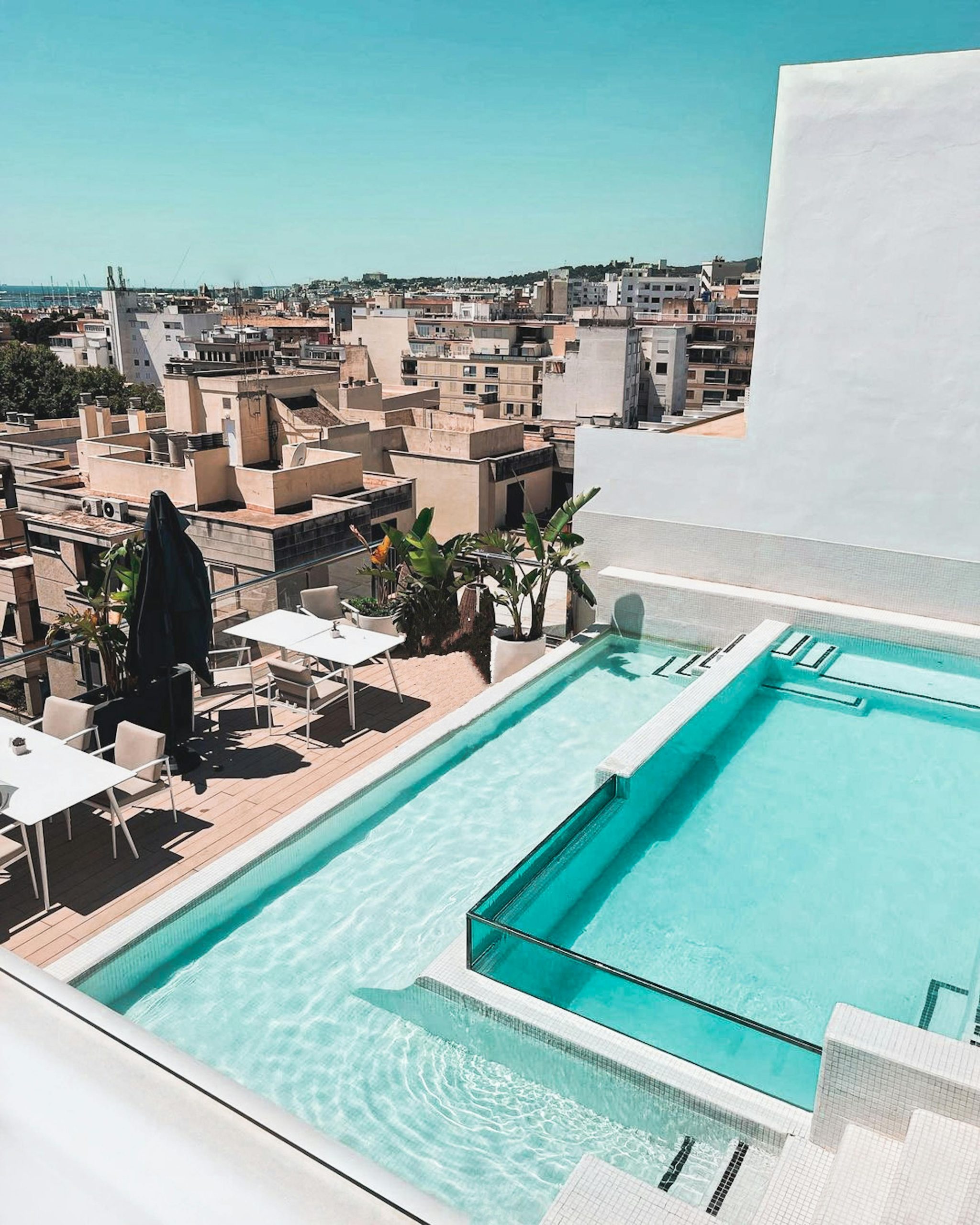 A beautiful rooftop terrace with a swimming pool overlooking a city's skyline, perfect for relaxation. Une belle terrasse de toit avec une piscine surplombant l'horizon d'une ville, parfaite pour la détente.