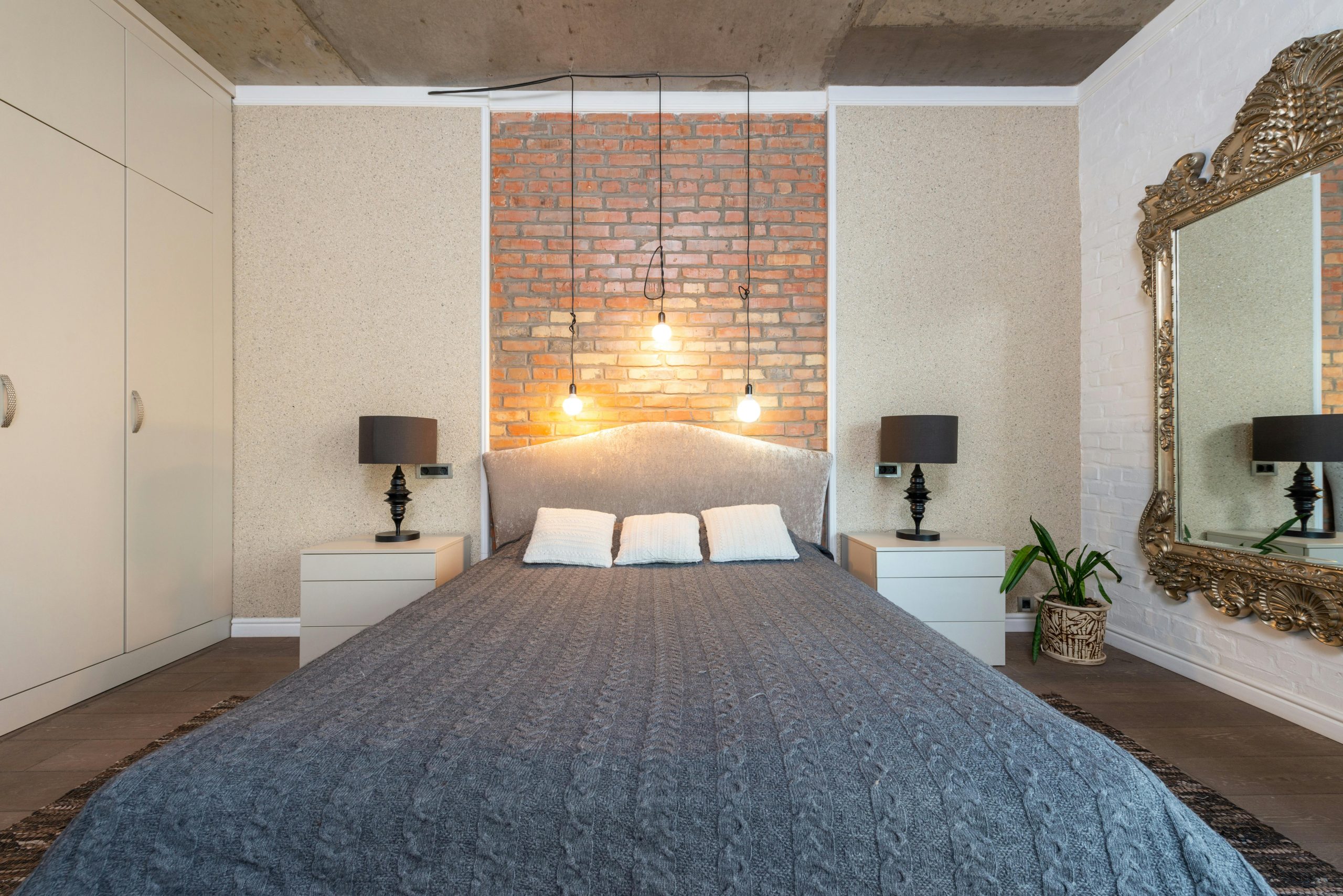 Contemporary bedroom featuring a stylish brick accent wall and elegant decor. Chambre contemporaine avec un mur d'accent en brique élégant et une décoration raffinée.