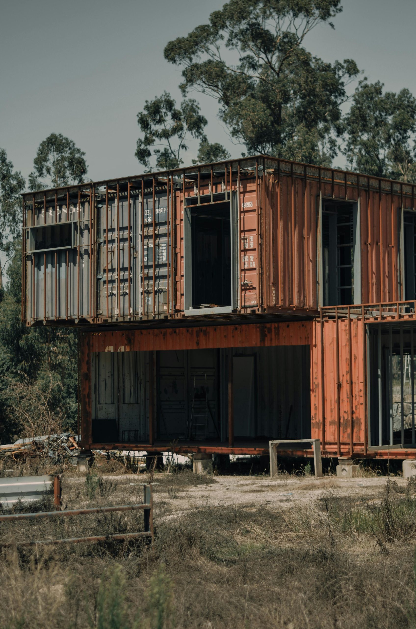 A rustic, container house structure set in a natural, wooded environment. Une structure de maison conteneur rustique dans un environnement naturel et boisé.