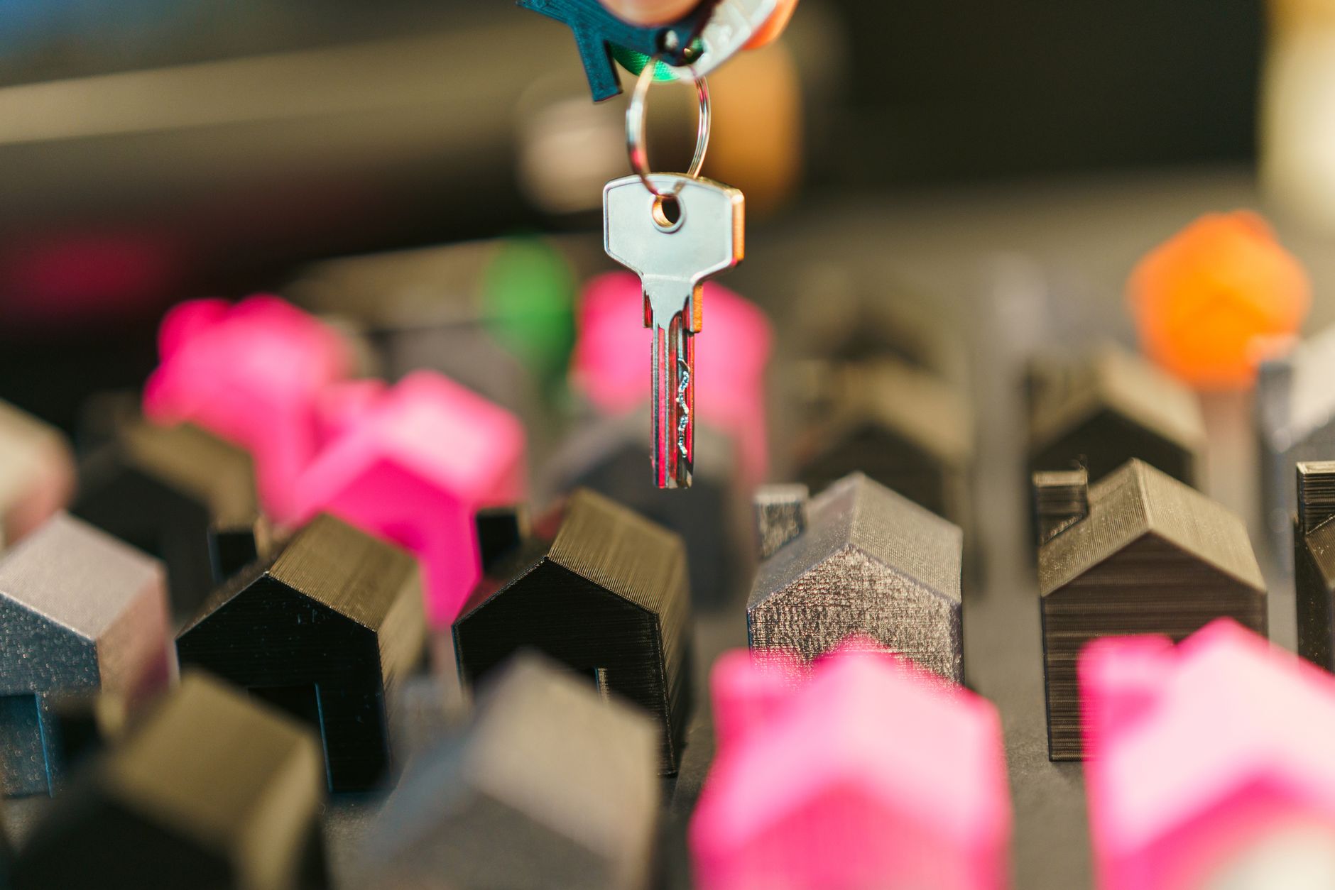 Clé tenue au-dessus d’une maquette de maison colorée