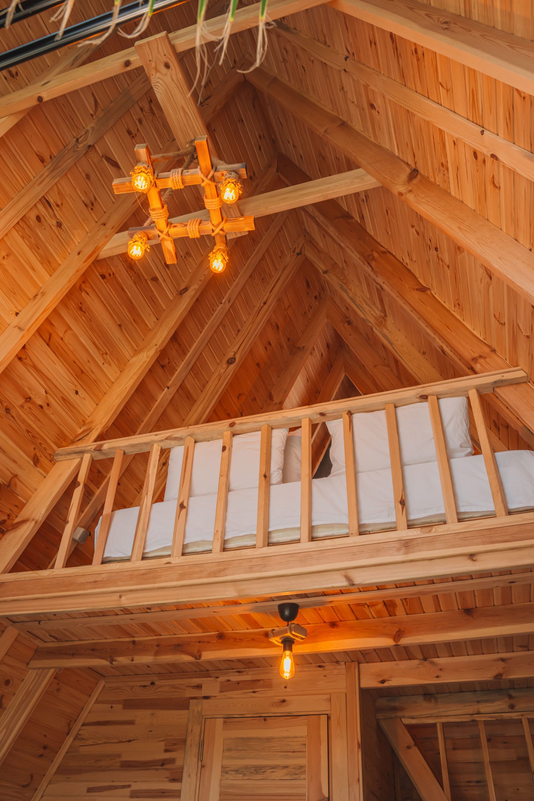 Warm rustic wooden interior of a loft with a cozy bed in Kemer, Antalya. Intérieur en bois rustique chaud d'un loft avec un lit douillet à Kemer, Antalya.