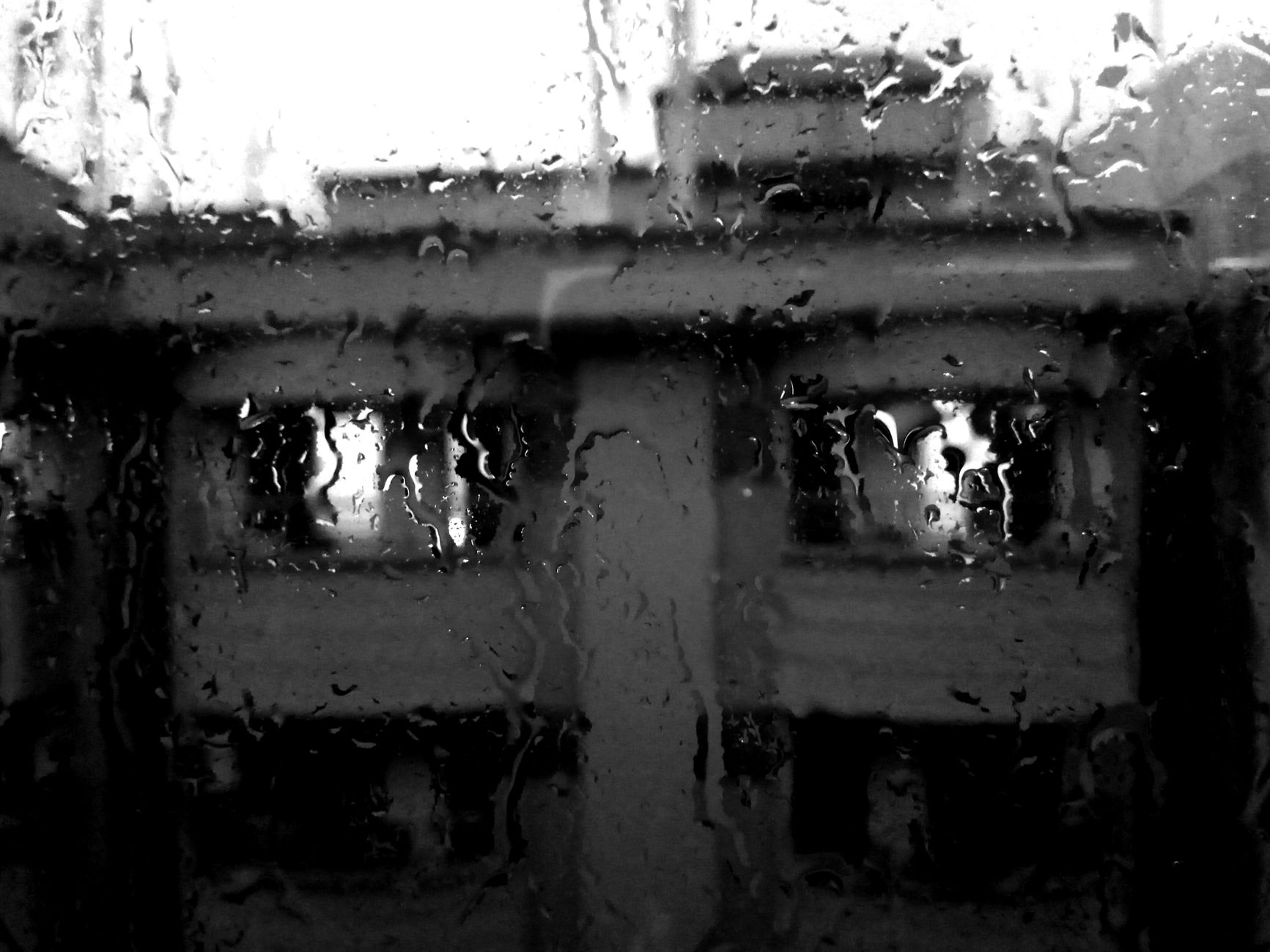 Façade de maison vue à travers une vitre sous la pluie