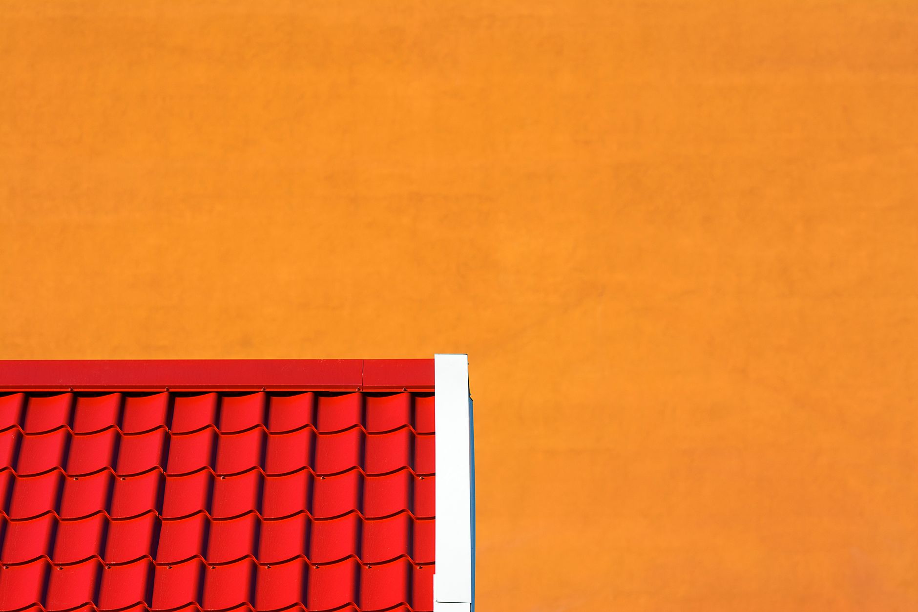 Toiture en tuiles rouges sur mur orange